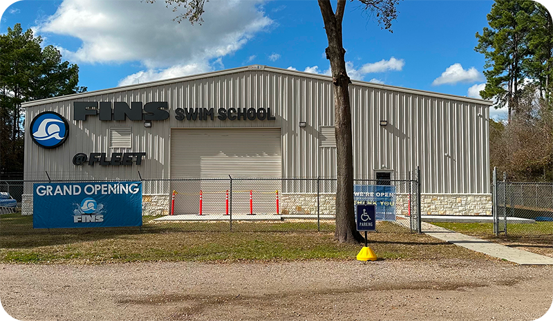 A student and instructor practicing professional swim techniques in the Spring, TX, indoor facility.